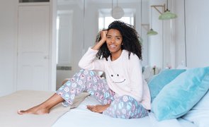 garota sentada na cama com pijamas de inverno